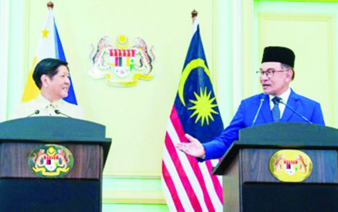 President Ferdinand R. Marcos Jr. (left) and Malaysian Prime Minister Anwar Ibrahim hold a joint press conference after their bilateral meeting in Kuala Lumpur on Wednesday, July 26. The two leaders agreed to convene the next Philippines-Malaysia Joint Commission meeting to discuss priority cooperation in areas of mutual interest, including in the halal industry. PHOTO COURTESY OF PRESIDENTIAL COMMUNICATIONS OFFICE