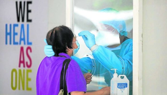 A woman undergoes swabbing procedures inside the UP-Philippine General Hospital. INQUIRER /LYN RILLON