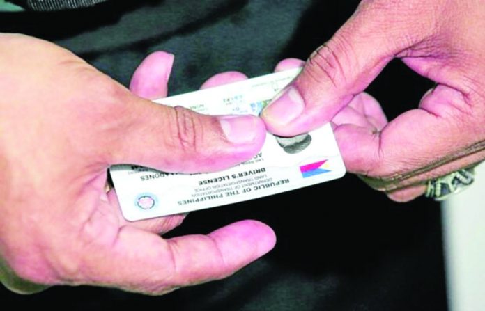 LICENSE CARDS. A staff of the Land Transportation Office shows a brand new student driver’s license at the Land Transportation Office Quezon City District Office in Centris Station. INQUIRER PHOTO/LYN RILLON