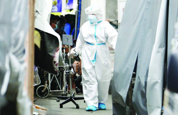 A medical worker at a hospital in Mandaluyong City checks COVID admissions. NIÑO JESUS ORBETA, PHILIPPINE DAILY INQUIRER