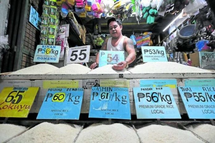 SIMULATED SHORTAGE? A rice vendor at Kamuning Public Market in Quezon City tends to his produce as the government readies rice imports. GRIG C. MONTEGRANDE, PHILIPPINE DAILY INQUIRER PHOTO