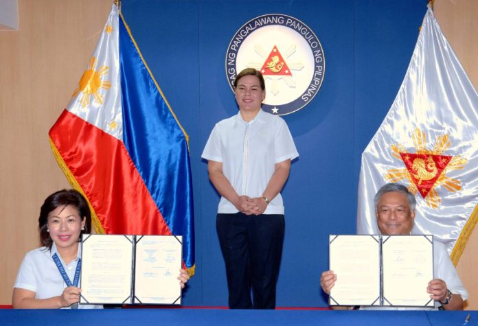 Vice President Sara Duterte stands in the background as PAGCOR Chairman and CEO Alejandro Tengco and OVP Chief of Staff Atty. Zuleika Lopez display the Memorandum of Agreement (MOA), which stated the state-run gaming and regulatory firm’s commitment to release P120 million worth of financial grant, in support of the OVP’s pro-poor advocacies.