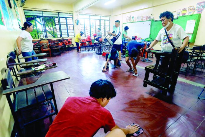 Volunteers clean a classroom at Araullo High School in Ermita, Manila as part of “Brigada Eskwela” maintenance activities. This initiative of parents, community officials, teachers, students and other stakeholders help public schools prepare for the opening of classes on Aug. 29. PNA