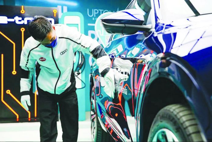 A worker cleans an electric vehicle at Uptown Bonifacio in Taguig City. JONATHAN CELLONA/ABS-CBN NEWS FILE PHOTO