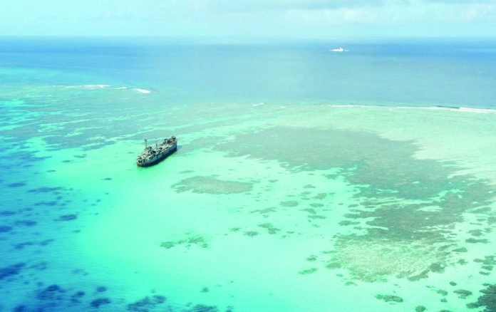 The BRP Sierra Madre, a Navy warship that now serves as military outpost, keeps watch over Ayungin (Second Thomas), located within the country’s exclusive economic zone. Nearby are Chinese coast guard and militia vessels in this shot taken on Feb. 21, 2023, during an aerial surveillance by the Philippine Coast Guard. PHILIPPINE DAILY INQUIRER/NIÑO JESUS ORBETA