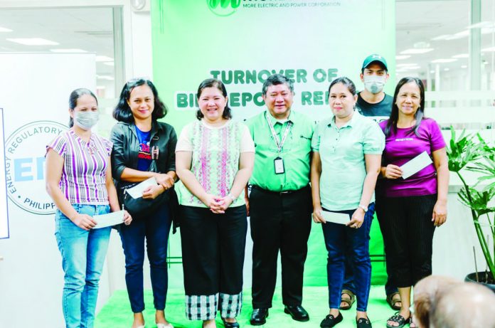 These eligible electricity consumers in Iloilo City are happy to receive their bill deposit refunds. They are shown here with Energy Regulatory Commission chairperson Monalisa C. Dimalanta (third from left) and MORE Electric and Power Corporation president Roel Z. Castro (fourth from left).