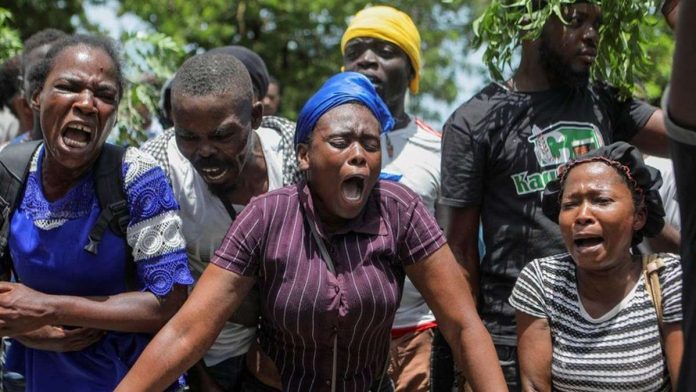 Haiti residents gather outside a military base demanding help. REUTERS