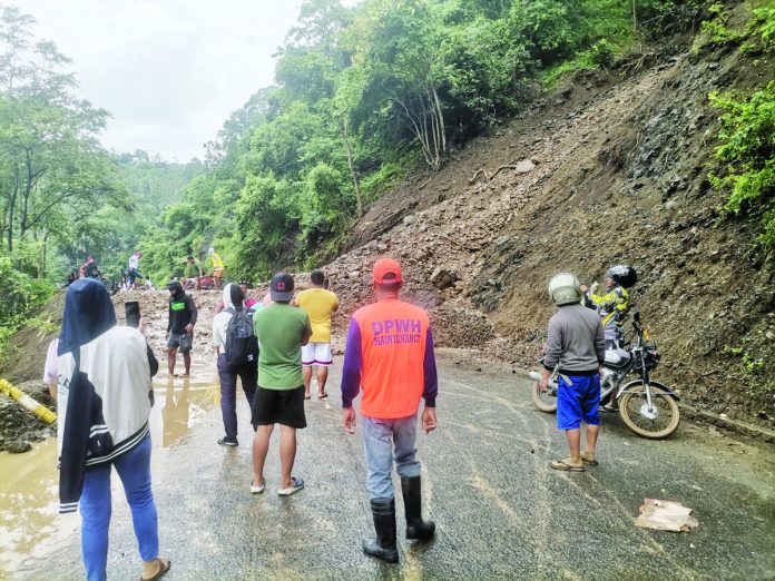 Residents and motorists climbed over piles of loose soil and rocks that temporarily closed the San Joaquin, Iloilo – Hamtic, Antique Road to all vehicle types on Sunday morning. SAN JOAQUIN DRRMC PHOTO