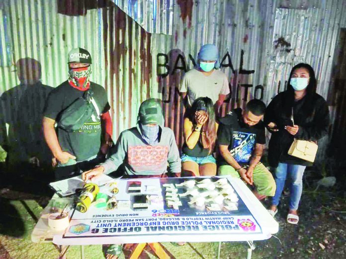 Rene Aguilar Paches and Jean Famucol Narciso (sitting, 1st and 2nd from right, respectively), tagged as high-value drug suspects, yield P3,876,000 worth of suspected shabu in a buy-bust operation on Jayme Street, Barangay Luna, Jaro, Iloilo City around 3:20 a.m. on Tuesday, Aug. 1. RPDEU-6 PHOTO