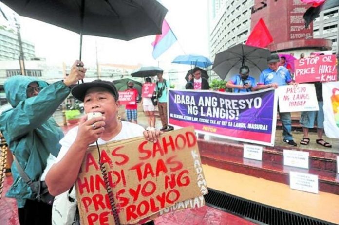 PRESSURE ON PRICES. Workers rally in Quezon City seeking a wage hike due to increased prices. Photo by NIÑO JESUS ORBETA / Philippine Daily Inquirer