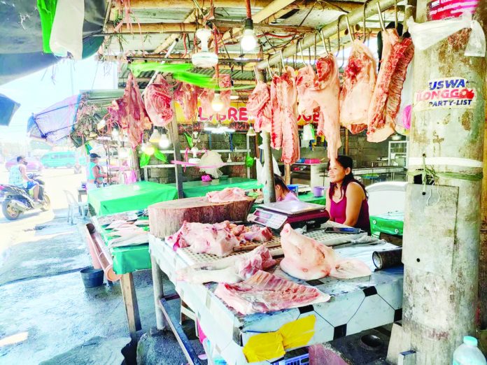 A vendor tends to her stall selling meat products at a market in Barangay Tagbak, Jaro, Iloilo City. PN FILE PHOTO