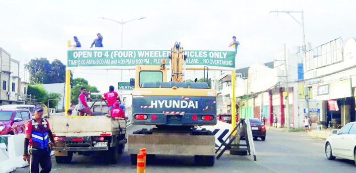 Personnel of the Iloilo City Government’s Public Safety and Transportation Management Office install a signage at the approach of the Ungka flyover in Barangay Ungka, Jaro, Iloilo City. The flyover will be open to light vehicles from 6 a.m. to 9 a.m. and 4 p.m. to 8 p.m. daily. PN PHOTO