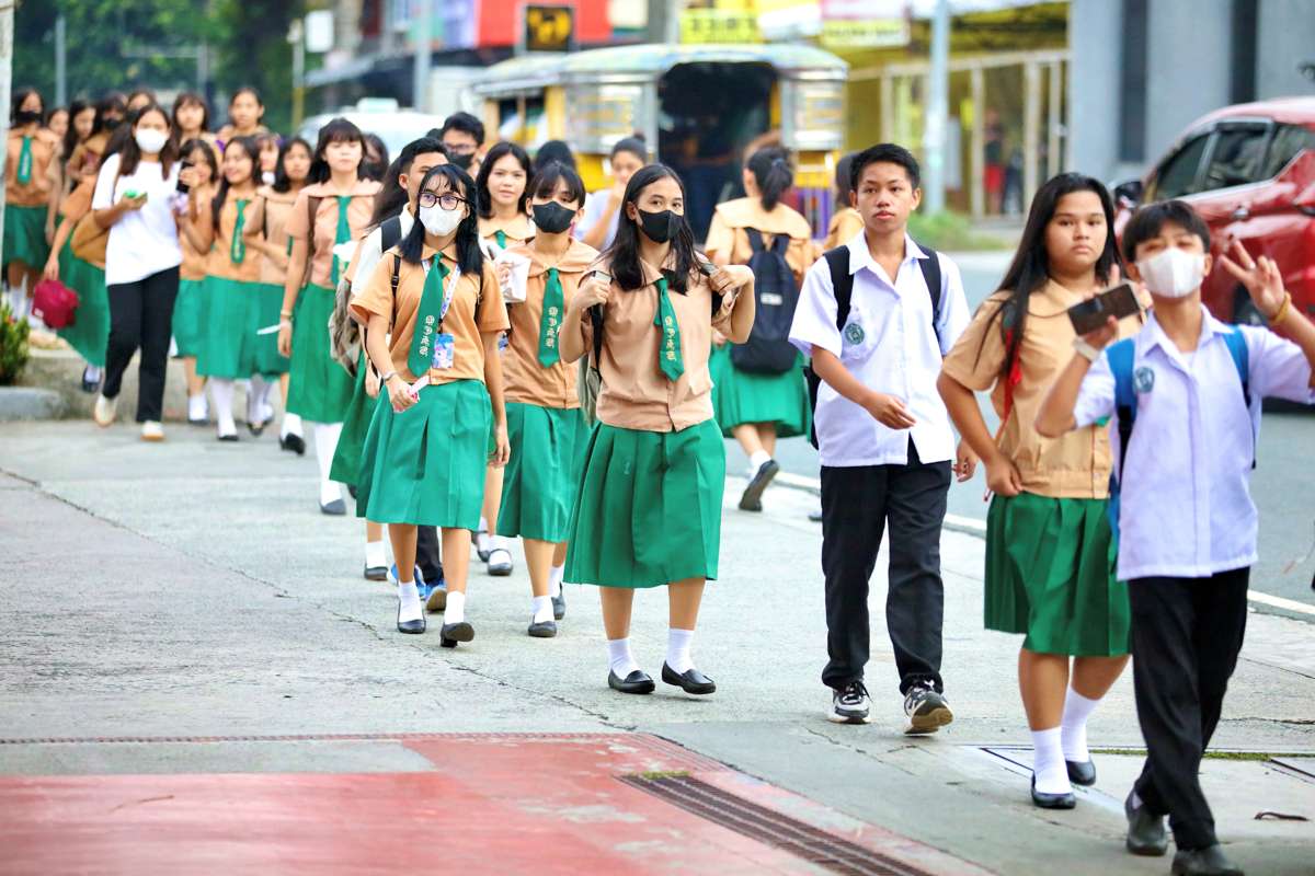 Students of the Quezon City High School troop to their school along Scout Ybardolaza Street, Barangay Sacred Heart, Quezon City. The Department of Education says more than 22.9 million students from public and private schools from kindergarten to senior high school have returned to school. PNA PHOTO