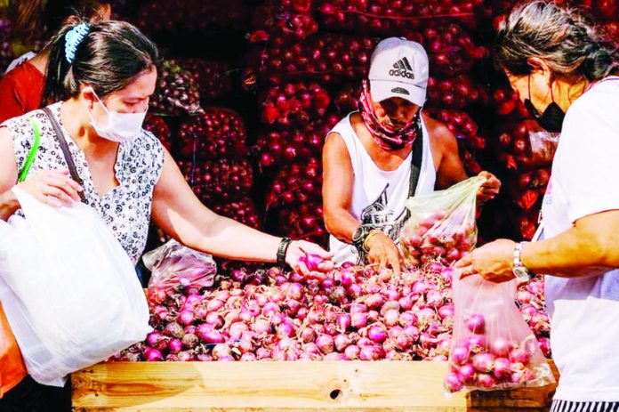 Customers sift through red onions at a stall in Divisoria market in Manila. GEORGE CALVELO/ABS-CBN NEWS PHOTO