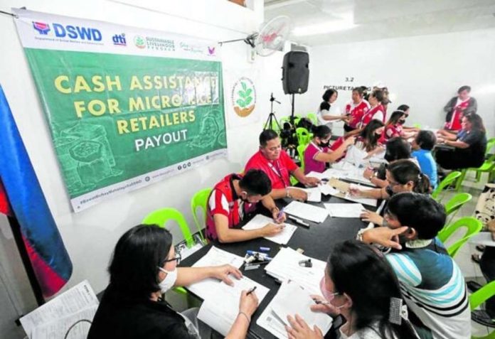 Social welfare workers distribute P15,000 in cash directly to small rice retailers at the Commonwealth Market in Quezon City. PHOTO BY LYN RILLON / PHILIPPINE DAILY INQUIRER