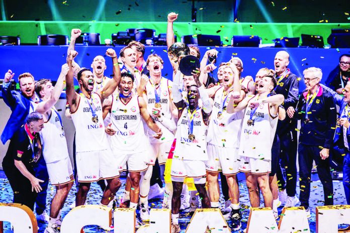 The 2023 FIBA Basketball World Cup champions Germany celebrate after defeating Serbian, 83-77, at the SM Mall of Asia Arena in Pasay City. Holding the trophy is FIBA 2023’s Most Valuable Player Dennis Schroder. FIBA PHOTO