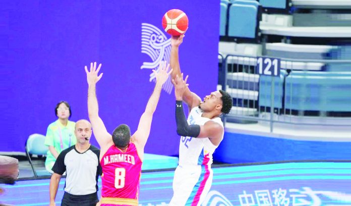 Gilas Pilipinas’ Justin Brownlee goes for a o ne-handed shot against the defense of a Bahrain player during their 19th Asian Games men's basketball game on Tuesday afternoon. PHOTO COURTESY OF POC