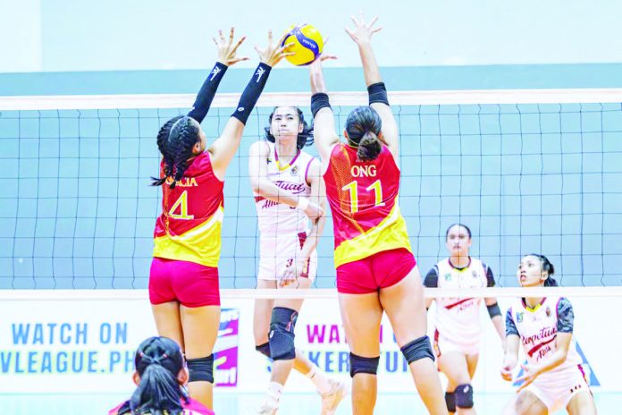 University of Perpetual Help Lady Altas’ Winnie Bedana smashes the ball towards two Mapua Lady Cardinals defenders. PHOTO COURTESY OF V-LEAGUE