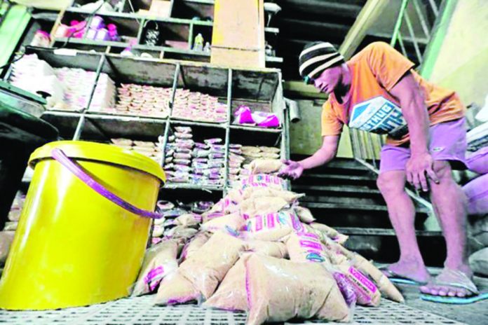 The threat of El Niño phenomenon could result in lower sugar output in the country in the next crop year. Photo shows a worker repacking sugar at a Quezon City public market. GRIG C. MONTEGRANDE/PHILIPPINE DAILY INQUIRER PHOTO