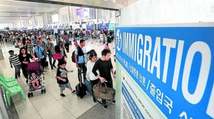 Departing passengers line up at the immigration counters of the Ninoy Aquino International Airport before boarding their respective flights. INQUIRER FILES