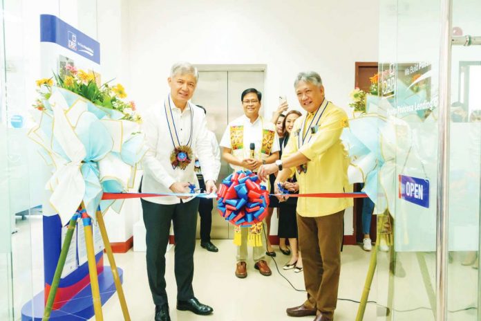 Development Bank of the Philippines President and Chief Executive Officer Michael O. de Jesus (left) leads the ribbon cutting ceremony for the opening of DBP Puerto Princesa Lending Center. Also in photo are Palawan’s Gov. Victorino Dennis M. Socrates (right) and guests from client-borrowers.