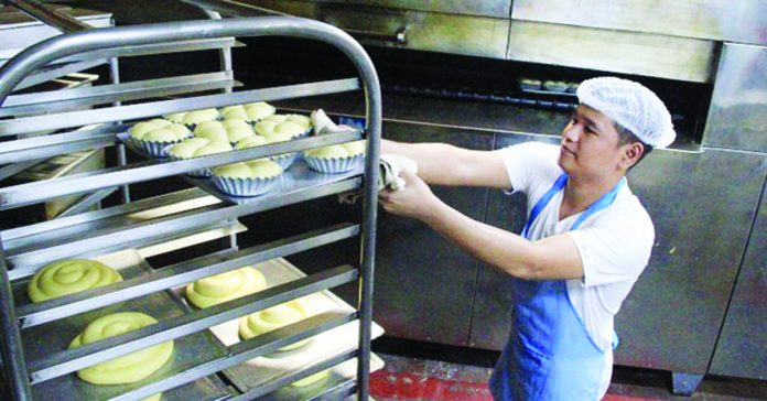 A baker prepares to put trays of dough into the oven at a bakery in Sampaloc, Manila on World Bread Day on Monday, Oct. 16. The occasion coincides with the creation of the UN Food and Agriculture Organization in 1945 to fight hunger, with the motto "Fiat Panis" (Let there be bread). PNA PHOTO BY ROBERT OSWALD ALFILER