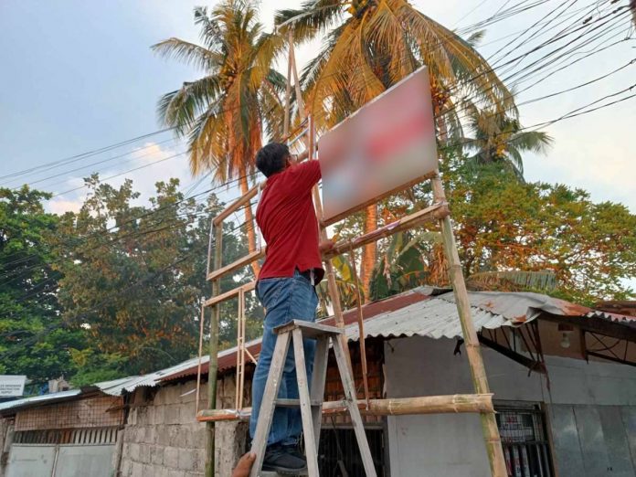 Jonathan Sayno, Election Assistant II of the Commission on Elections-Iloilo City, leads the removal of illegal campaign posters in Arevalo district. AJ PALCULLO/PN