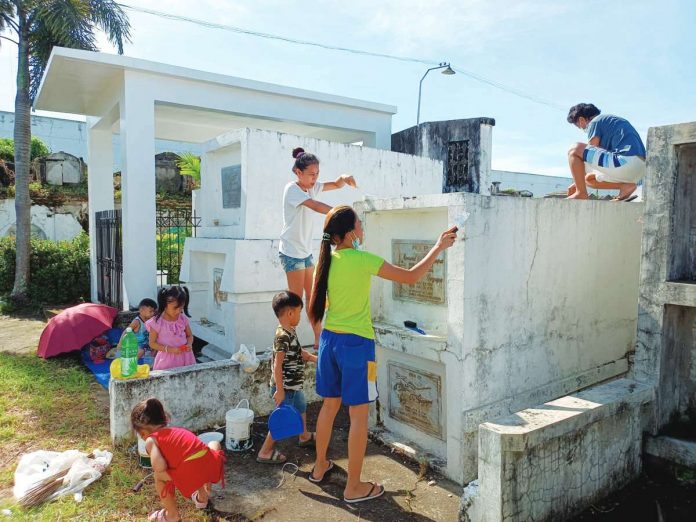 The Department of Health advises the public not to bring small children to cemeteries to keep them from getting injuries and catching diseases from overcrowding. Photo shows family members, including children, cleaning and painting the tombs of their departed loved ones at the Jaro Catholic Cemetery in Jaro, Iloilo City. AJ PALCULLO/PN
