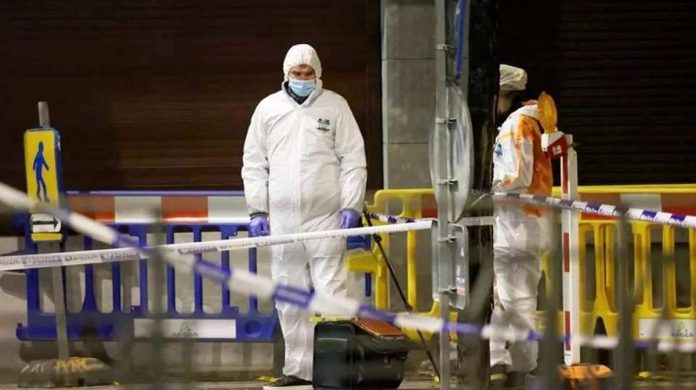 Belgian police officers search for evidence after two people were killed during a shooting in Brussels. REUTERS