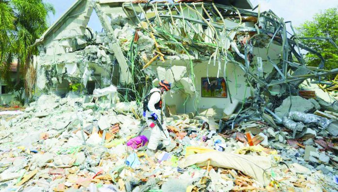 An Israeli soldier walks past a house destroyed by Hamas militants in Kibbutz Be'eri on Wednesday, Oct. 11. Two Ilongga overseas Filipino worker sisters from Maasin, Iloilo were abducted by Palestinian terror group, Hamas, in Kibbutz Be’eri on Oct. 7. The younger sibling was rescued but the elder sibling was taken by militants. ASSOCIATED PRESS PHOTO