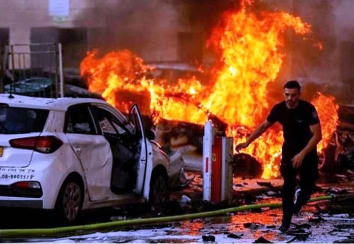 A Palestinian man runs away from a burning building in the Gaza Strip that Israel has struck with missiles. BBC