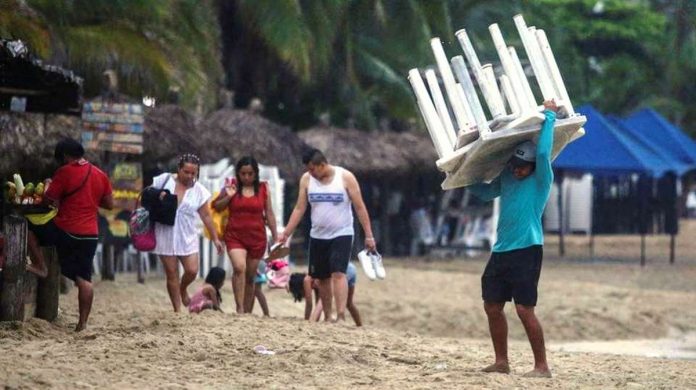 A man removes tables off a beach as Hurricane Otis barrels towards Acapul, Mexico. Residents in the hurricane’s path have been urged to move to emergency shelters. REUTERS