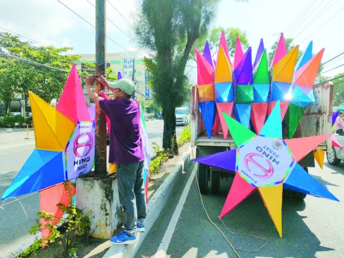 Iloilo City Engineer’s Office personnel install rainbow Christmas parols on the city’s major streets. AJ PALCULLO/PN