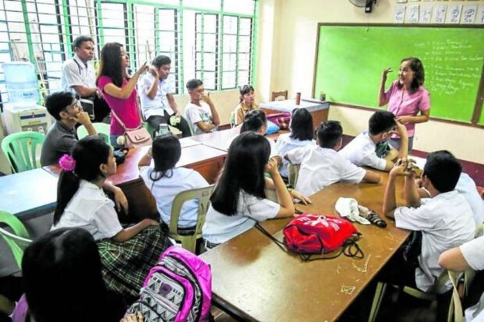 A teacher at Ramon Magsaysay (Cubao) High School in Quezon City addresses concerns raised by her students during the start of classes in this 2018 photo. INQUIRER FILE PHOTO