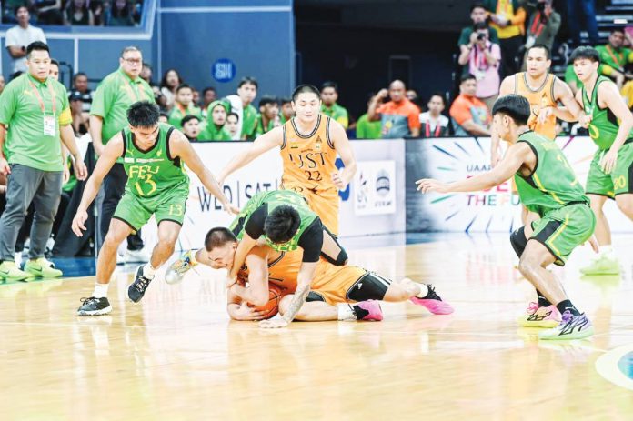 University of Santo Tomas Growling Tigers’ Nicael Cabañero protects the ball while being clobbered by Far Eastern University Tamaraws’ Royce Alforque. UAAP PHOTO