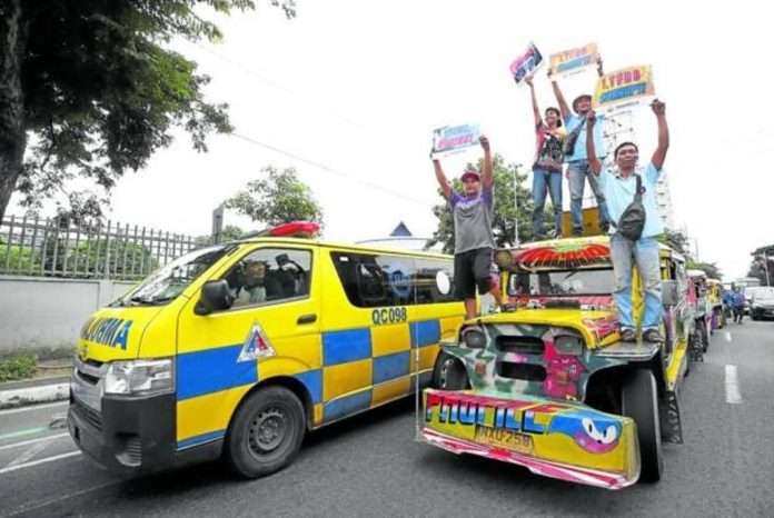 Public utility vehicle drivers use a jeepney as a platform to air their grievances against the government’s transportation agencies and officials during the strike led by the group Manibela on Monday. Their protest caravan stopped on East Avenue in Quezon City before proceeding to Manila. PHOTO BY LYN RILLON, PHILIPPINE DAILY INQUIRER