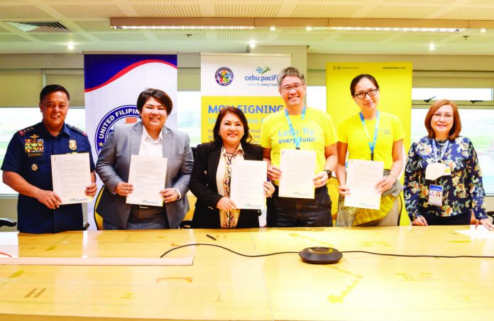 Officials from Cebu Pacific, United Filipino Global (UFG), Department of Migrant Workers (DMW), Overseas Workers Welfare Administration (OWWA), and Philippine National Police (PNP) pose for a photo after the memorandum of understanding signing: (from left) PNP Deputy Chief Administrator Lieutenant General Rhodel Sermonia, DMW Undersecretary Patricia Yvonne Caunan, UFG President Gemma Sotto, Cebu Pacific President and Chief Commercial Officer Xander Lao, Cebu Pacific Chief Marketing and Customer Experience Officer Candice Iyog, and OWWA director Rosalia Catapang.