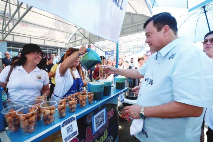 Mayor Jerry Treñas makes a cashless purchase from this food stall at the Iloilo Terminal Market on Thursday, Nov. 23. This food stall now accepts digital payments through Paleng-QR Ph Plus. ILOILO CITY MAYOR’S OFFICE PHOTO