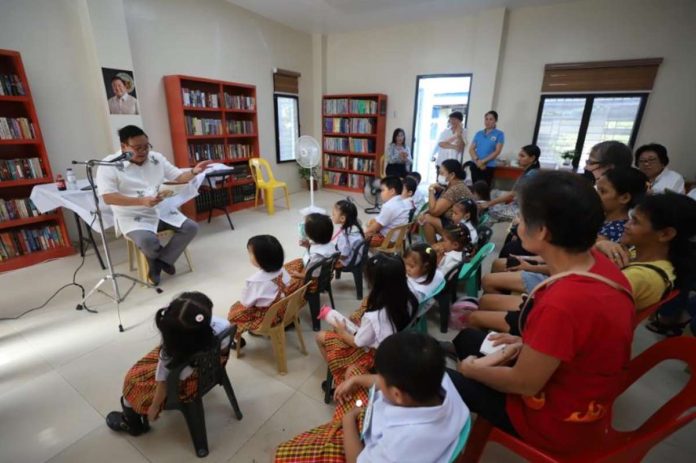 Mayor Jerry Treñas reads a story to daycare children during the inauguration of Nabitasan Reading Center in Barangay Nabitasan, La Paz, Iloilo City on Nov. 9. ILOILO CITY GOVERNMENT PHOTO