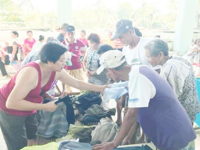 Senior citizen residents of a barangay in Concepcion, Iloilo receive clothes during a gift-giving activity. RAUL BANIAS FILE PHOTO