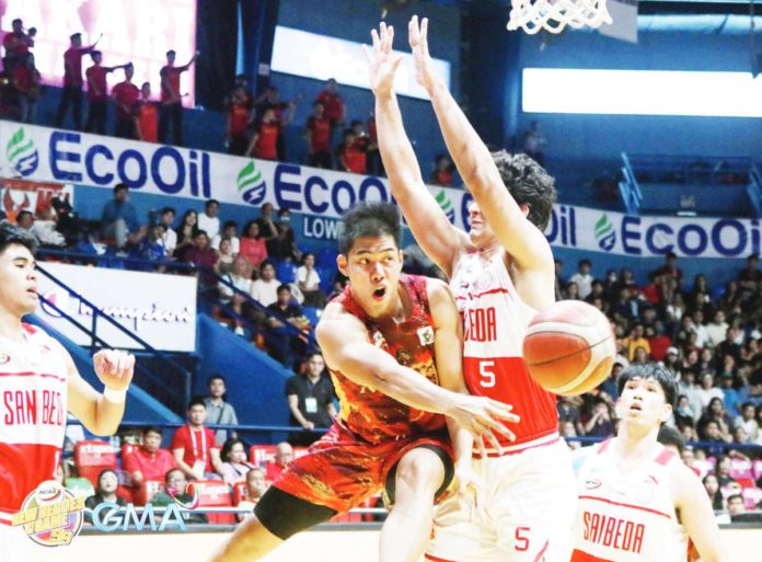 Mapua University Cardinals’ Paolo Hernandez dishes a pass after being trapped by the defense of a San Beda University Red Lions player. PHOTO COURTESY OF NCAA/GMA SPORTS