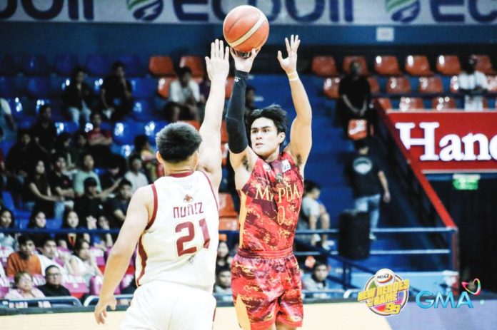 Mapua University Cardinals’ Clint Escamis drills a three-pointer against a University of Perpetual Help Altas defender. PHOTO COURTESY OF NCAA/GMA SPORTS