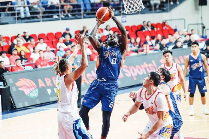 Meralco Bolts’ Suleiman Braimoh attacks the defense of Rain or Shine Elasto Painters’ Keith Datu and Rey Mark Belo for an inside hit. PBA PHOTO