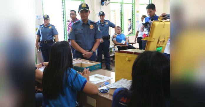 Poll workers at the Daniel R. Aguinaldo National High School in Talomo, Davao City wait for voters as policemen look on during the conduct of the barangay and Sangguniang Kabataan elections on Oct. 30, 2023. PNA