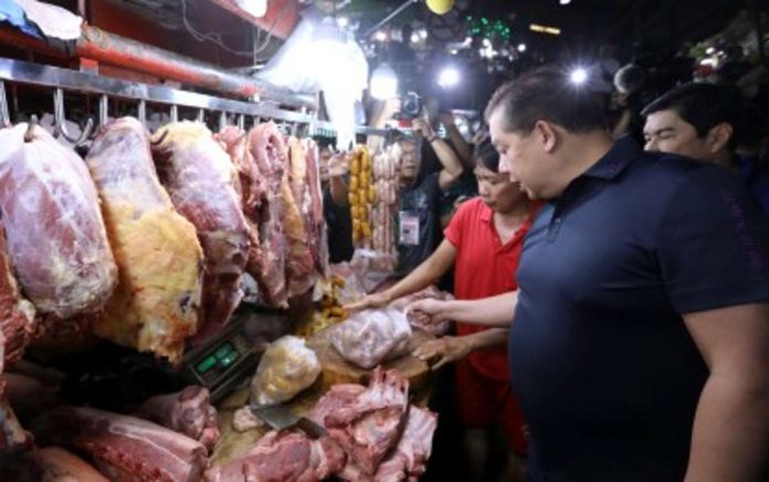 House Speaker Martin Romualdez checks on the meat section of the Farmers Market in Quezon City on Monday, Nov. 27. Romualdez made the rounds with Deputy Majority Leader Erwin Tulfo (partly hidden) to ensure that prices of basic commodities are within the limits of suggested retail prices as the holidays are approaching. PNA PHOTO