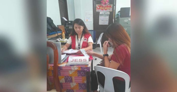 An employee of the Department of Social Welfare and Development Region 6 facilitates the releasing of cash assistance to the family of one of the victims of the tragic bus accident in Barangay Igbucagay, Hamtic, Antique. DSWD-6 PHOTO