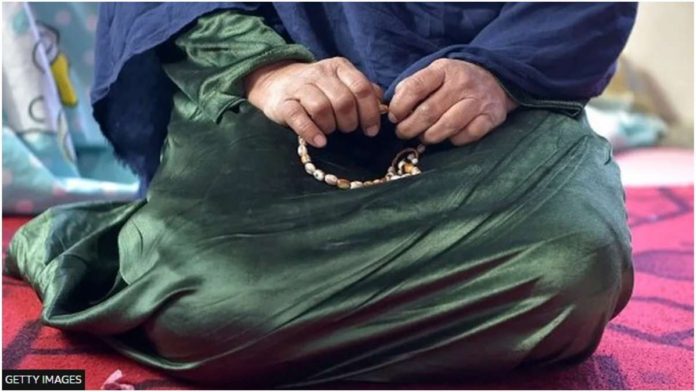 An Afghan woman sits while holding prayer beads. The Taliban's suppression of women's rights in Afghanistan is one of the harshest in the world. GETTY IMAGES