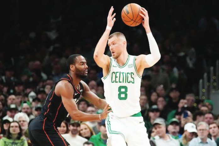 Boston Celtics center Kristaps Porzingis (8) sets to drive against Detroit Pistons guard Alec Burks. AP PHOTO/CHARLES KRUPA