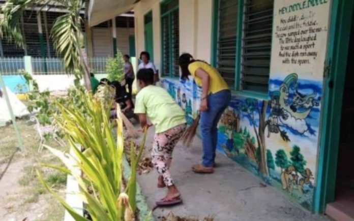 Parents and teachers in a public school in Iloilo clean the school surroundings to destroy the breeding grounds of mosquitoes in this file photo. PHOTO COURTESY OF DOLLYN MONTA FABILLO