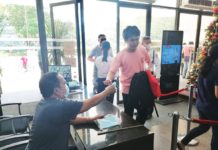 Iloilo City Hall employees and visitors are strongly advised to wear facemasks again. Photo shows a city hall security guard handing out a facemask to a visitor. GLENDA TAYONA PHOTO